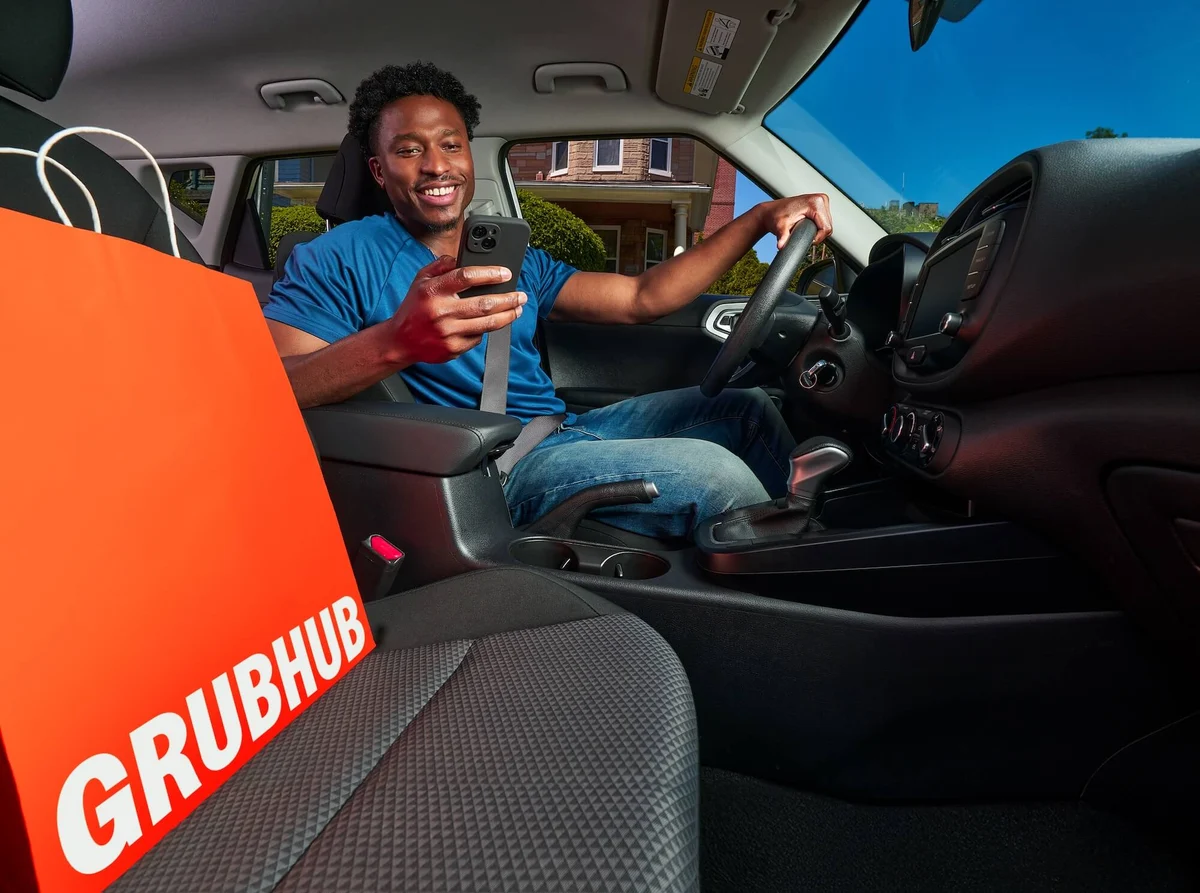 Repartidor dentro de un coche con una bolsa de Grubhub