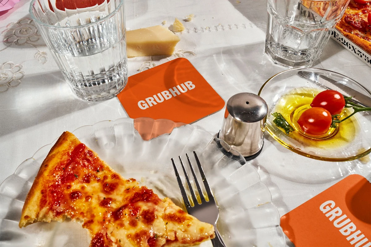 Pizza y bebidas sobre una mesa con una bolsa de Grubhub