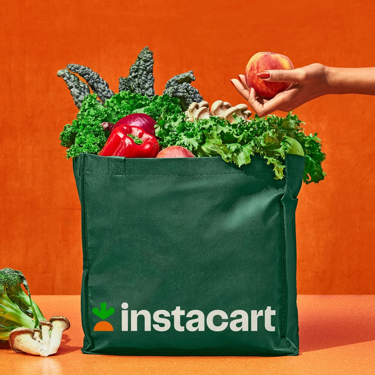 Instacart grocery bag with produce on orange