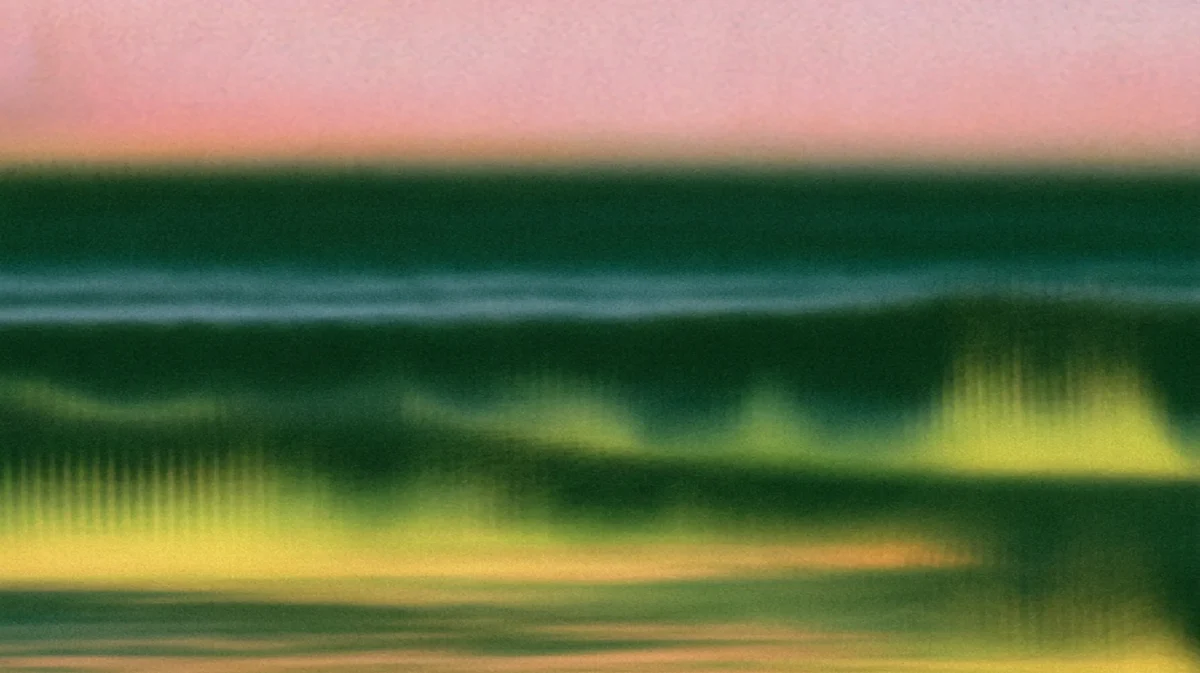 Abstract image with horizontal green, yellow, and pink bands, evoking the feel of a blurry landscape or seascape at sunset, with a soft, hazy, and gradient effect throughout.
