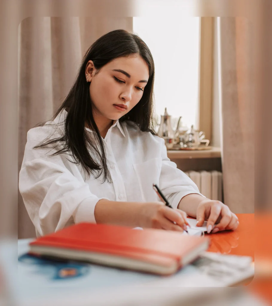 Okta brand photography: a woman writing at a desk