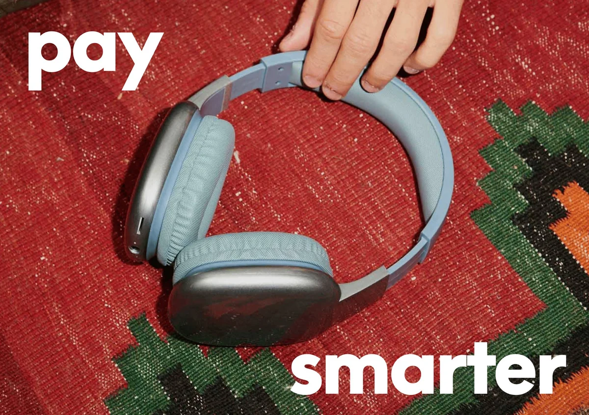 Anuncio de PayPal «pay smarter» con auriculares sobre una alfombra tejida