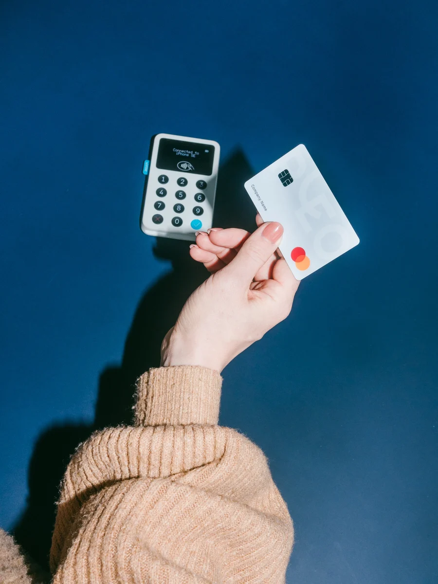 Hand holding a Pleo card on blue