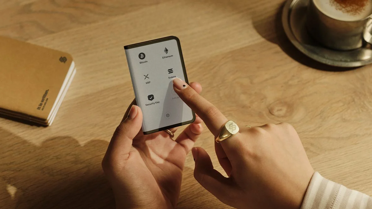 Manos sosteniendo un teléfono con la app de Solflare en la mesa de una cafetería