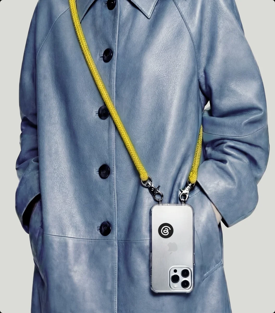 Modelo llevando un cordón para el móvil con una funda de Threads