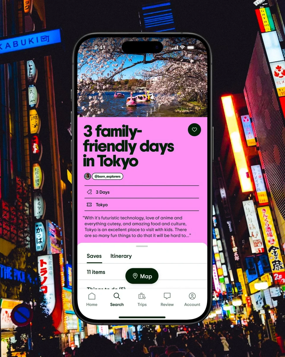 Phone showing Tripadvisor trip guides over a Tokyo street