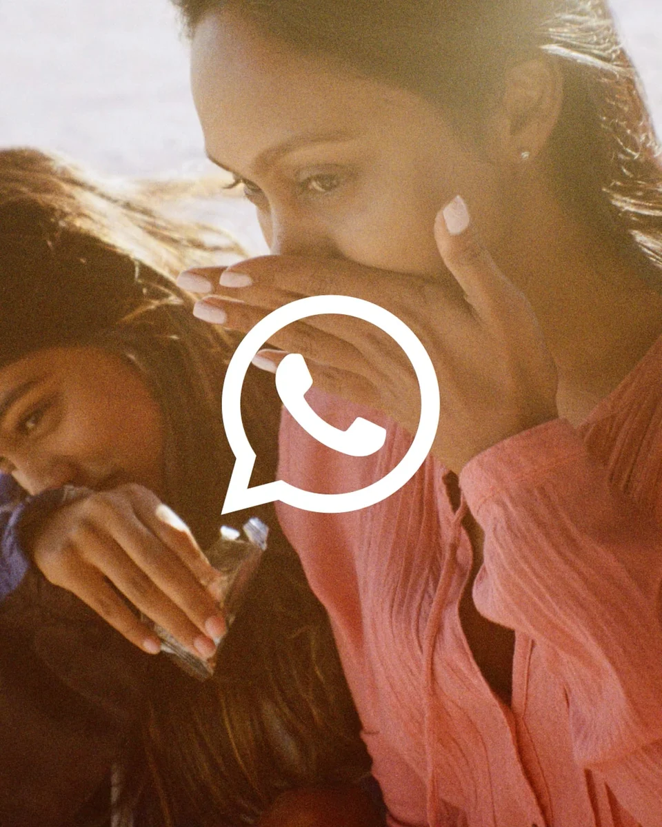 WhatsApp logo over a photo of a woman on a phone