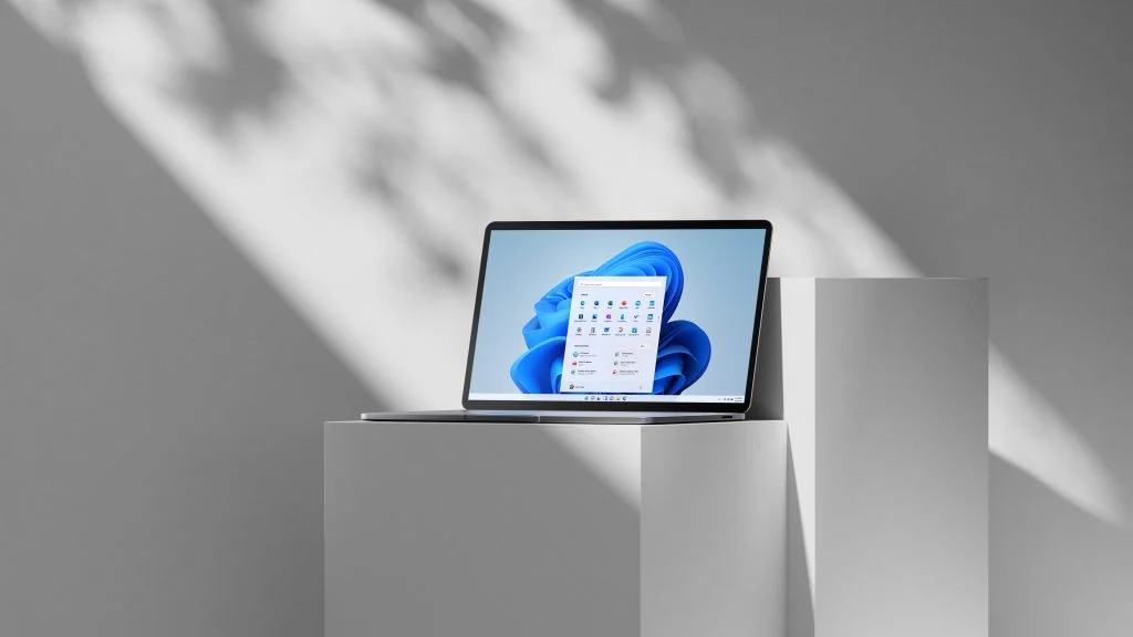 Laptop running Windows 11 on a plinth in soft light