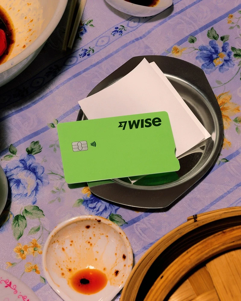 Tarjeta verde de Wise en un plato con un mantel floral